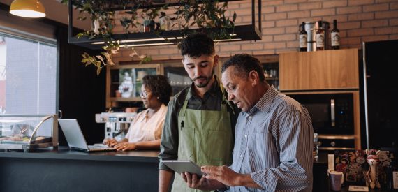 Coffee shop owner talking to employee